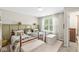 Charming bedroom with twin beds, a patterned accent wall, and a bright window with decorative curtains at 12259 Sweet Creek Trl, Fishers, IN 46037
