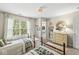 Bright bedroom showcasing twin beds, a dresser with a rattan mirror, and a large window for natural light at 12259 Sweet Creek Trl, Fishers, IN 46037