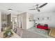 Bright bonus room features a ceiling fan, red sofa, and playful decor, offering a versatile living space at 12259 Sweet Creek Trl, Fishers, IN 46037