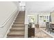 Inviting entryway with a staircase, modern console table, and a glimpse into the living and dining areas at 12259 Sweet Creek Trl, Fishers, IN 46037