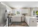 Cozy kitchen features stainless steel appliances, white cabinetry, and view of backyard at 12259 Sweet Creek Trl, Fishers, IN 46037