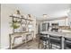 Stylish kitchen featuring a breakfast bar, stainless steel appliances, and decorative shelving at 12259 Sweet Creek Trl, Fishers, IN 46037