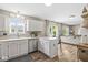 Well-lit kitchen with white cabinets, stainless steel appliances, and a view of the living room at 12259 Sweet Creek Trl, Fishers, IN 46037