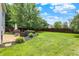 Lovely backyard featuring a stone patio, grill, an umbrella and a large, level lawn at 12322 Cool Winds W Way, Fishers, IN 46037