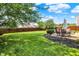 Spacious backyard with a well-maintained lawn, privacy fence, and an outdoor dining set on a patio at 12322 Cool Winds W Way, Fishers, IN 46037