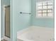 Bright bathroom featuring a soaking tub under a window and a glass-enclosed shower at 12322 Cool Winds W Way, Fishers, IN 46037