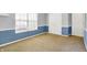 This bedroom features neutral carpet, blue accent walls and baseboards, and a large window with lots of natural light at 12322 Cool Winds W Way, Fishers, IN 46037