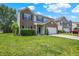 Inviting two-story home with a brick and vinyl facade, green lawn, and a convenient two-car garage, perfect for suburban living at 12322 Cool Winds W Way, Fishers, IN 46037