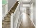 Hallway with a staircase, neutral walls, tiled floor, and white trim, offering a bright and airy transition through the home at 12322 Cool Winds W Way, Fishers, IN 46037