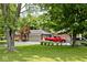 A red truck sits in front of this brick home with lush greenery, offering a suburban charm at 1345 Westwind Dr, Avon, IN 46123