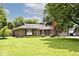 A charming brick home with green lawn, mature trees, and an inviting landscape at 1345 Westwind Dr, Avon, IN 46123