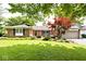 Charming brick home with a well-maintained lawn and mature trees, offering curb appeal at 1345 Westwind Dr, Avon, IN 46123