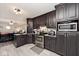 Traditional kitchen with dark cabinets and stainless steel appliances open to the living room at 1345 Westwind Dr, Avon, IN 46123