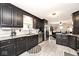 Spacious kitchen features stainless steel appliances, dark cabinetry, and gray-tiled floors at 1345 Westwind Dr, Avon, IN 46123