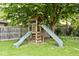Backyard playground set with two slides and a wooden deck and fence at 1345 Westwind Dr, Avon, IN 46123