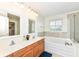 Bright bathroom with double vanity, soaking tub, and tiled surround at 14109 Secretariat Ct, Carmel, IN 46074