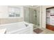 Elegant bathroom with a glass shower, soaking tub, and large window at 14109 Secretariat Ct, Carmel, IN 46074