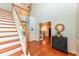 Elegant foyer with a staircase, hardwood floors, a decorative table, and a view into a bright office space at 14109 Secretariat Ct, Carmel, IN 46074