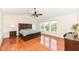 Bright main bedroom featuring hardwood floors, a ceiling fan, and multiple windows for plenty of natural light at 14109 Secretariat Ct, Carmel, IN 46074