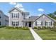 Charming two-story home with gray siding, black shutters, and a beautifully landscaped front yard with colorful flowers at 14234 Community Dr, Carmel, IN 46033
