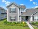 Charming gray home with black shutters and a covered porch, enhanced by vibrant flowers and manicured landscaping at 14234 Community Dr, Carmel, IN 46033