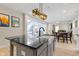 Kitchen island featuring a large black countertop, modern pendant lighting, and stainless steel appliances at 14234 Community Dr, Carmel, IN 46033