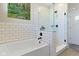 Bathroom featuring a bathtub, shower with glass door, and tile surround at 14234 Community Dr, Carmel, IN 46033