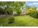 View of a large green backyard with a wood fence and mature trees at 14492 Cotswold Ln, Carmel, IN 46033