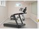 This finished basement features exercise equipment, carpeting, and natural light from windows, ideal for a home gym at 14492 Cotswold Ln, Carmel, IN 46033