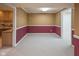 This finished basement is carpeted with neutral walls featuring accent colors and is adjacent to an area with built-in cabinetry at 14492 Cotswold Ln, Carmel, IN 46033