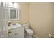 Cozy half bathroom with white vanity and a framed mirror, complete with essentials at 14492 Cotswold Ln, Carmel, IN 46033
