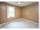 This bedroom features neutral carpeting, light tan walls, a ceiling fan and a large window for ample natural light at 14492 Cotswold Ln, Carmel, IN 46033