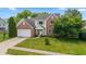 Aerial view of home with brick and white siding, front lawn, landscaping, and two car garage at 14492 Cotswold Ln, Carmel, IN 46033