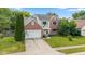 Aerial view of home with brick and white siding, front lawn, landscaping, basketball hoop, and two car garage at 14492 Cotswold Ln, Carmel, IN 46033