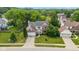 Aerial view of home with brick and white siding, large lawn, landscaping, and two car garage at 14492 Cotswold Ln, Carmel, IN 46033