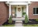 Inviting front porch with a decorative wreath, chair, and charming details that add curb appeal at 14492 Cotswold Ln, Carmel, IN 46033