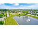 Aerial view of a serene community featuring a lake, playground, and tree-lined streets at 15178 Silver Charm Dr, Noblesville, IN 46060