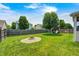 Fenced backyard featuring a playset, fire pit, and lush lawn, creating an ideal space for outdoor enjoyment at 15178 Silver Charm Dr, Noblesville, IN 46060