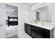 Tastefully appointed bathroom featuring double vanity, modern lighting and decor, with view to the primary bedroom at 15178 Silver Charm Dr, Noblesville, IN 46060