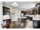 Bright kitchen with stainless steel appliances, dark cabinets, central island and an adjacent dining area at 15178 Silver Charm Dr, Noblesville, IN 46060