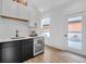 Well-appointed wet bar featuring built-in mini fridge, white cabinets and sink at 1834 Rosette Way, Indianapolis, IN 46202