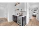 Stylish wet bar area with a sink, mini fridge, and white upper cabinets at 1834 Rosette Way, Indianapolis, IN 46202