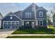 Charming two-story home features a blue exterior, well-manicured lawn, and an attached two-car garage at 18955 Seaforth Way, Westfield, IN 46074
