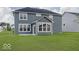 Back exterior of a two-story home with gray siding, large windows, and a green lawn at 18955 Seaforth Way, Westfield, IN 46074