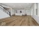 Open-concept living room featuring light-colored floors, stairs and an island kitchen with modern appliances at 18955 Seaforth Way, Westfield, IN 46074