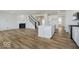 Open-concept kitchen and living room with fireplace and large kitchen island, and light-colored wooden floors at 18955 Seaforth Way, Westfield, IN 46074