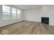 Living room with hardwood floors, white walls, a fireplace, and large windows at 18955 Seaforth Way, Westfield, IN 46074