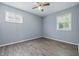 Bedroom with gray wood-look floors, a ceiling fan, and two windows at 1931 Brentwood Dr, Anderson, IN 46011
