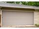 Wide garage door in a light-colored home exterior with a well-maintained lawn and landscaping at 196 Park Ave, Bargersville, IN 46106