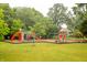 Colorful playground equipment with swings, slides, and a soft landing surface surrounded by greenery at 196 Park Ave, Bargersville, IN 46106